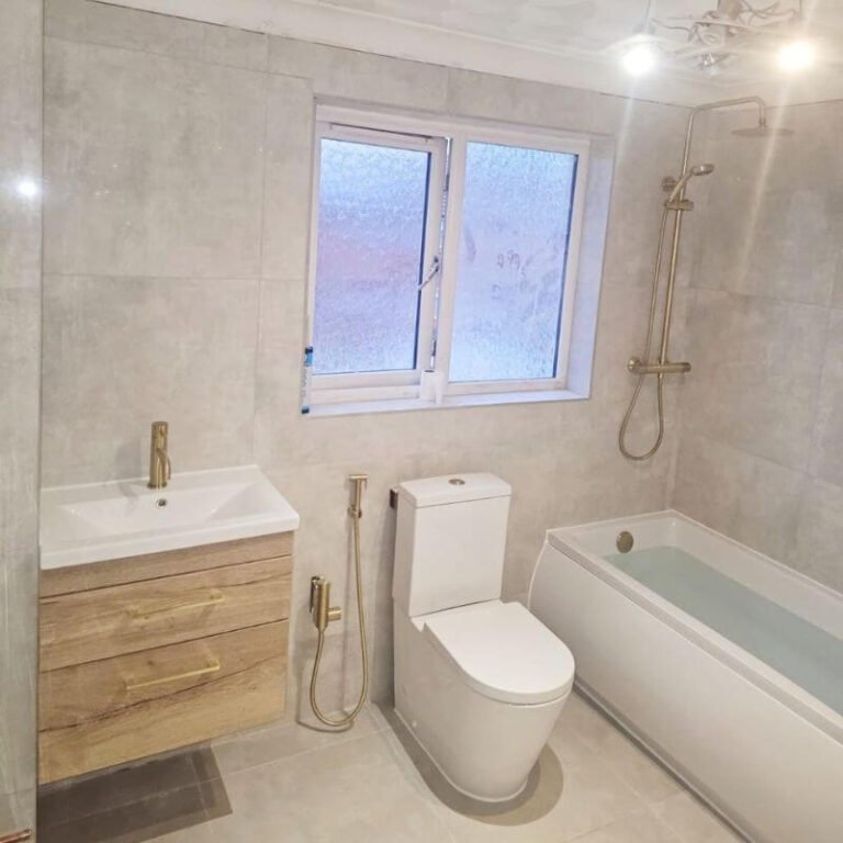 Renovated bathroom in South West London with grey tiles, wood vanity and bath with rain shower