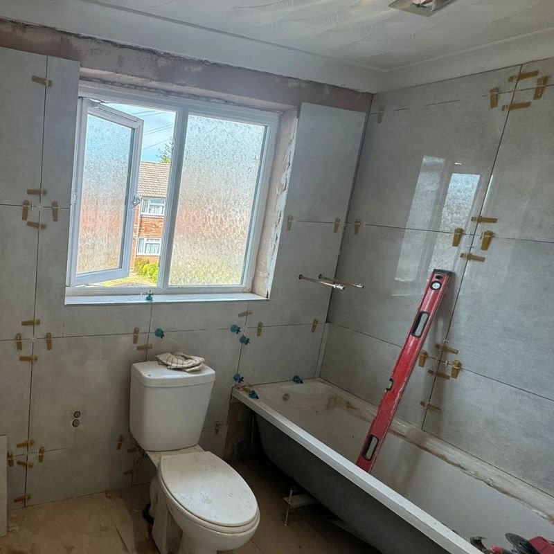 Bathroom walls tiled around the window with levelling clips
