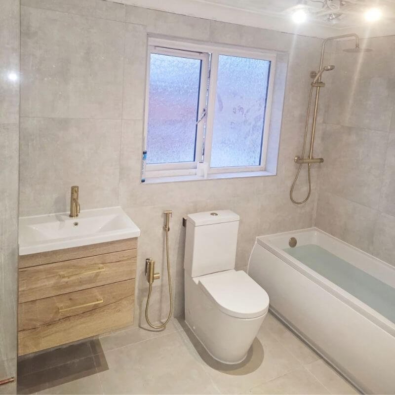 Finished bathroom with vanity unit, brushed brass taps and thermostatic shower