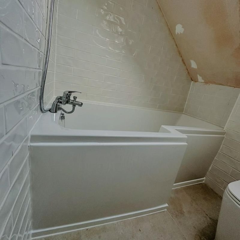 Loft bathroom with L-shaped shower bath and metro wall tiles